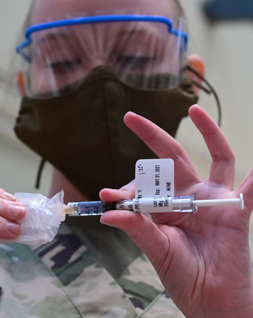 a national guard officer prepares to give a vaccine at the va hospital