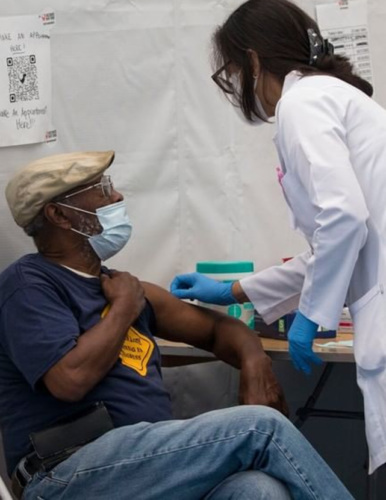 an elderly African American man getting a vaccine