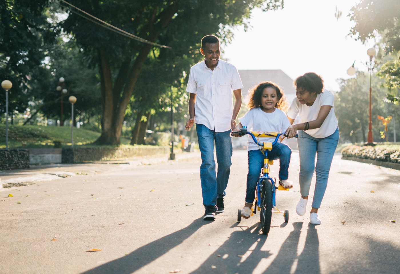 Family teaching a kid to bike