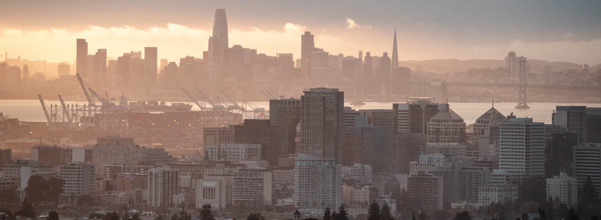 a smoggy view of the Oakland and San Francisco skylines