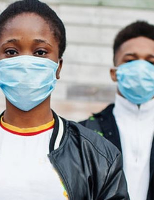 Two African Americans in blue medical masks looking into the camera