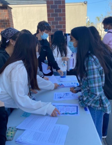 FACES peer educators handing out information at a high school event