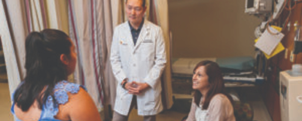 an emergency department doctor and colleague speaking with a patient