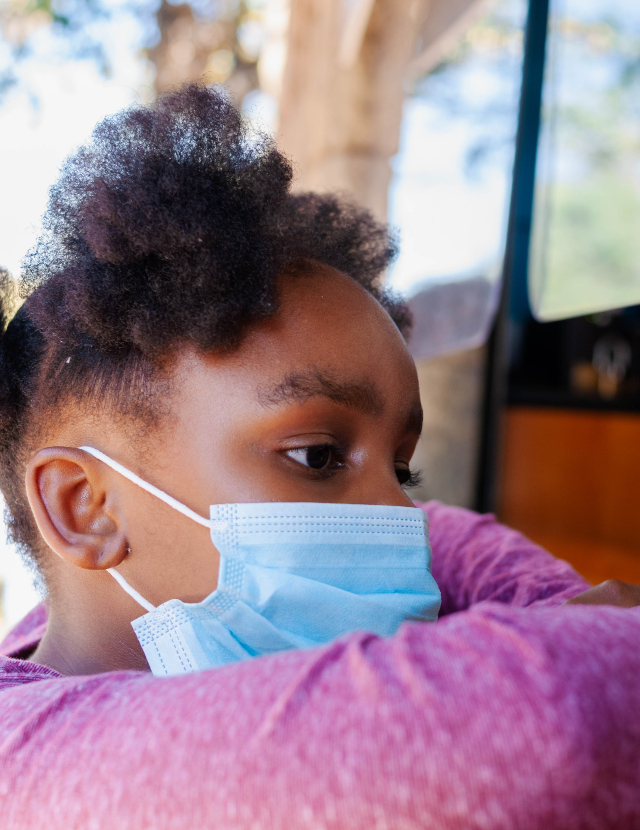 a young African American girl wearing a medical face mask