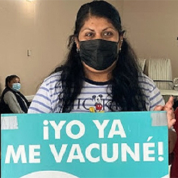 woman holding sign that says Yo Ya Me Vacune