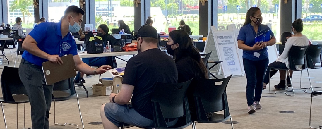 people in medical masks at a vaccination clinic