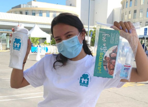 a woman at a vaccine event holding up information packets