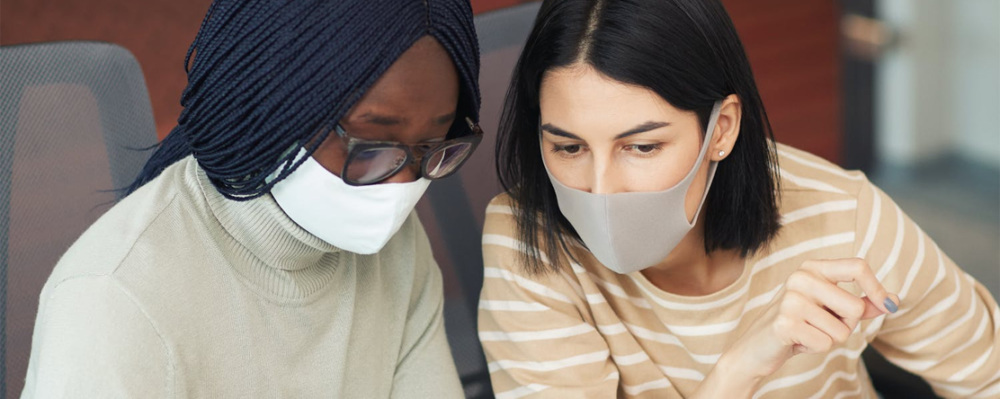 two women at work wearing mask