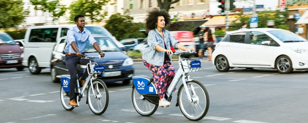 Two people biking on a city street