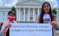 Two girls holding a sign in support of the Health Equity and Racial Justice Fund