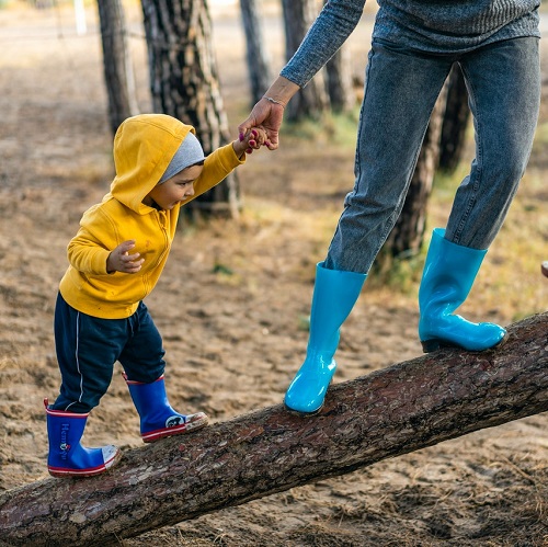 Child and parent balancing on a log