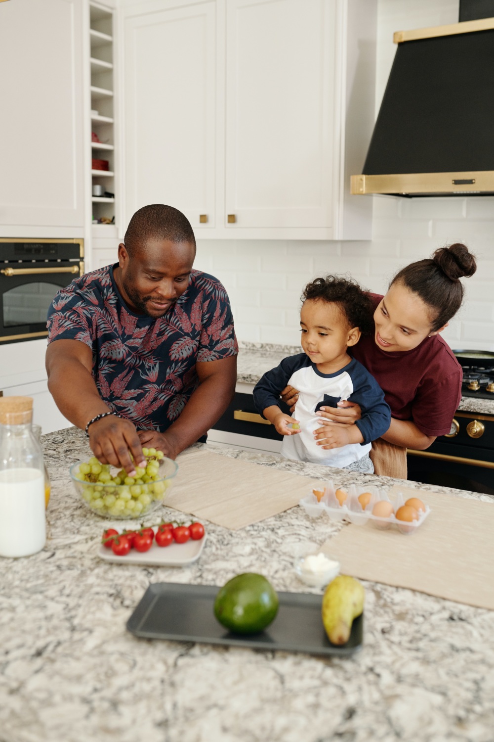 mom dad and child preparing healthy food at home