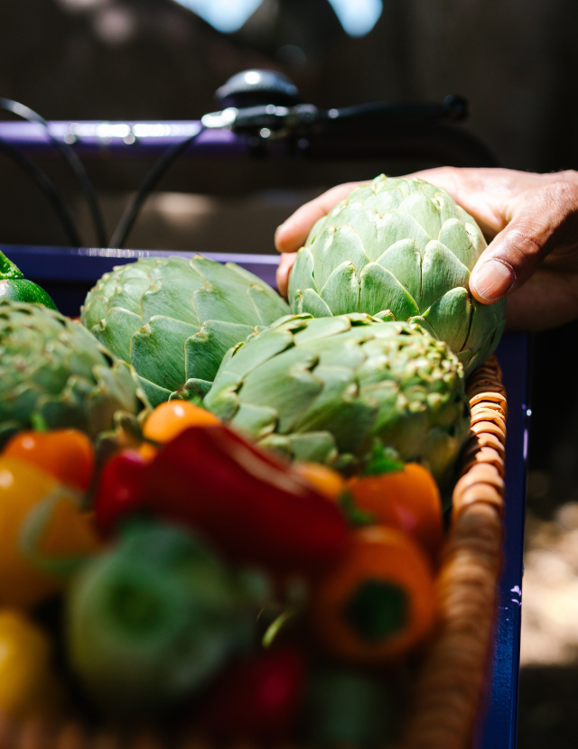 Hand reaching for an artichoke