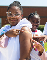 Young adult showing a bandaid on their arm after receiving a vaccine