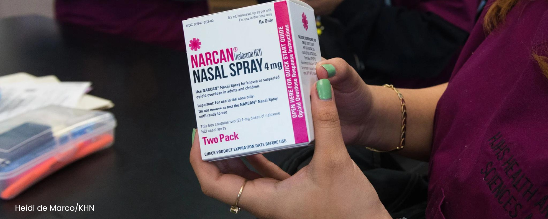 student in the workshop holding a narcan kit