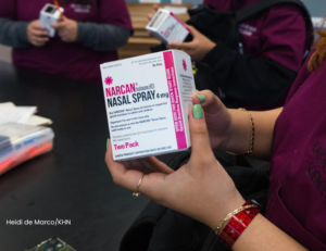 student in the workshop holding a narcan kit