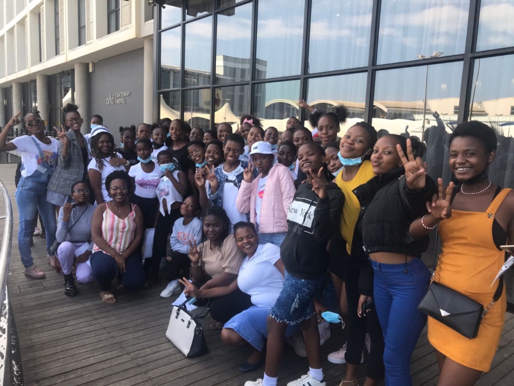 The latest cohort of Rise Up girl leaders in South Africa standing in front of a hotel.