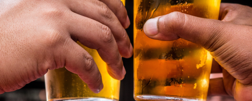 two people making a toast with their glass of beer