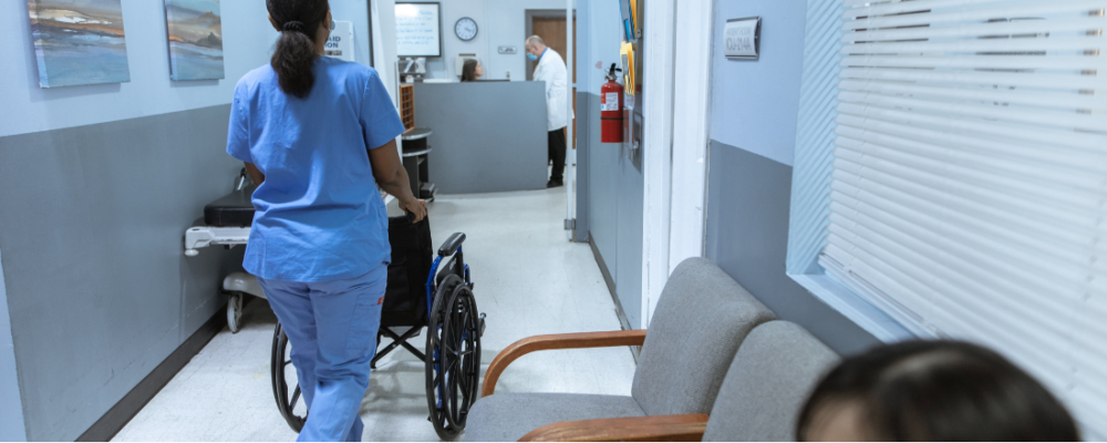 nurse pushing a wheelchair in the emergency room