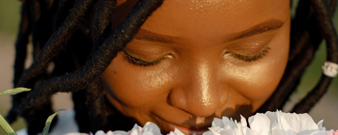 young girl sniffing flower