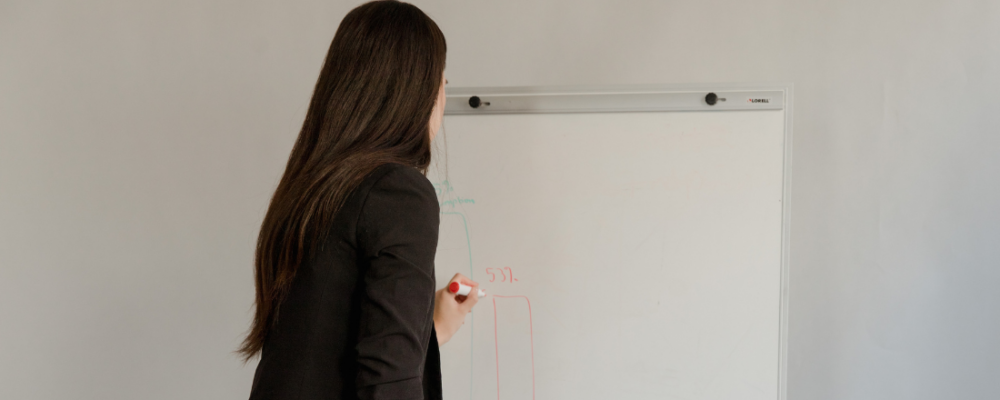 Woman writing on a white board