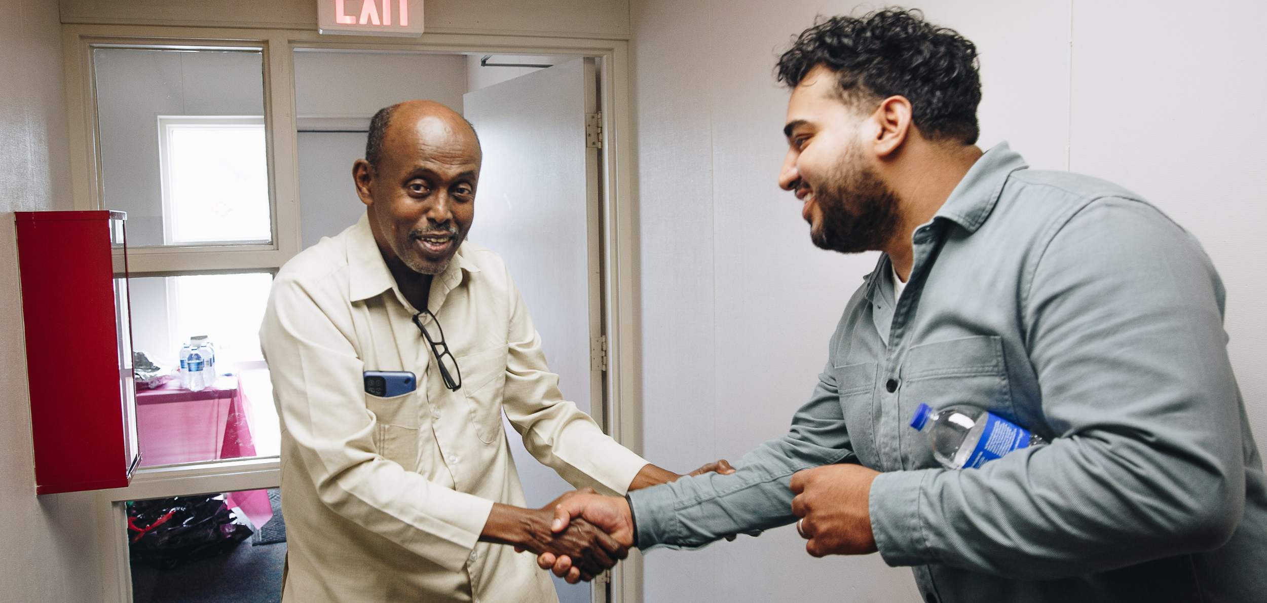 Doctor and custodian, shaking hands in a hallway