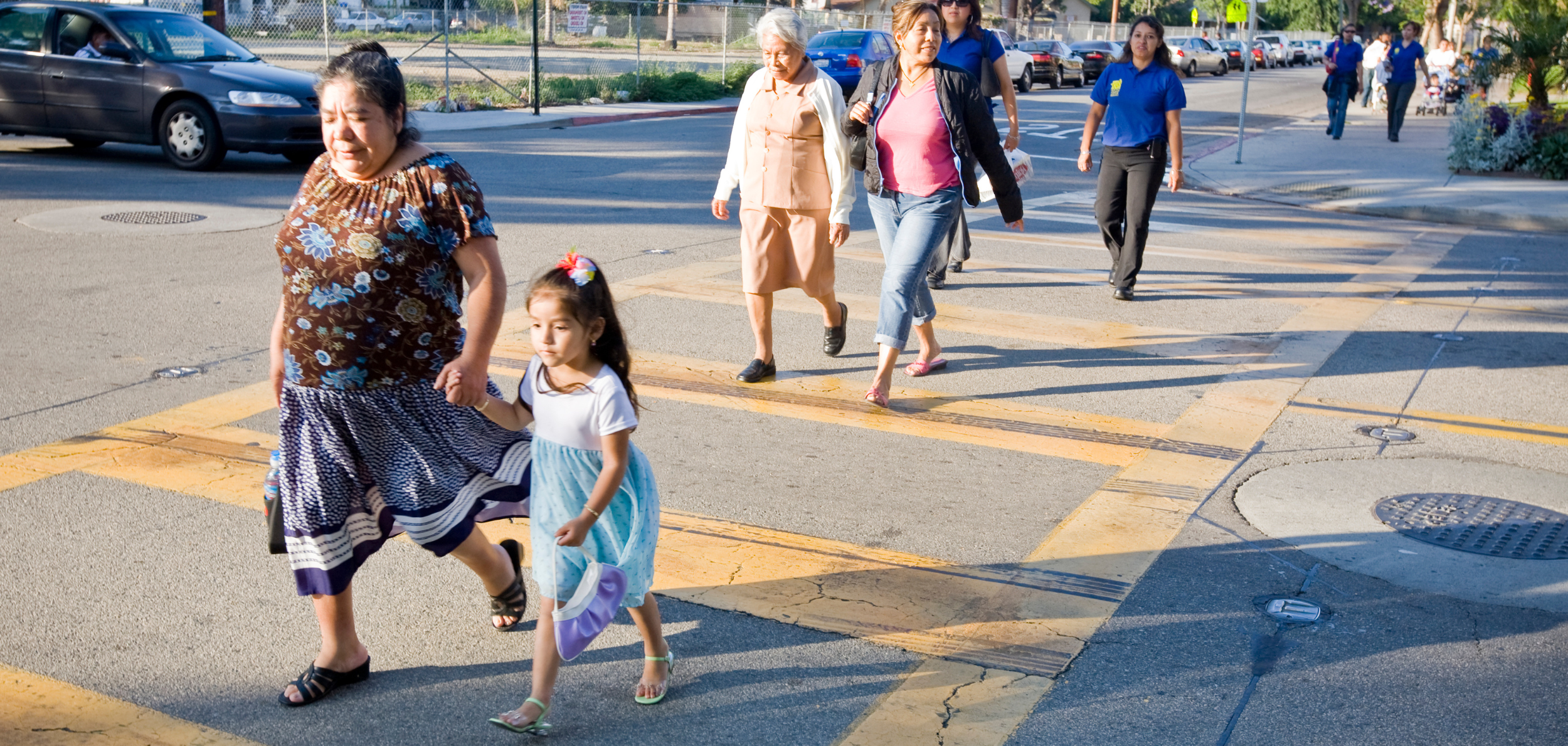 A line of a families from a predominantly Latino neighborhood in Santa Ana walk to a community town hall event to identify, discuss and plan on how to handle their community's health and safety issues.