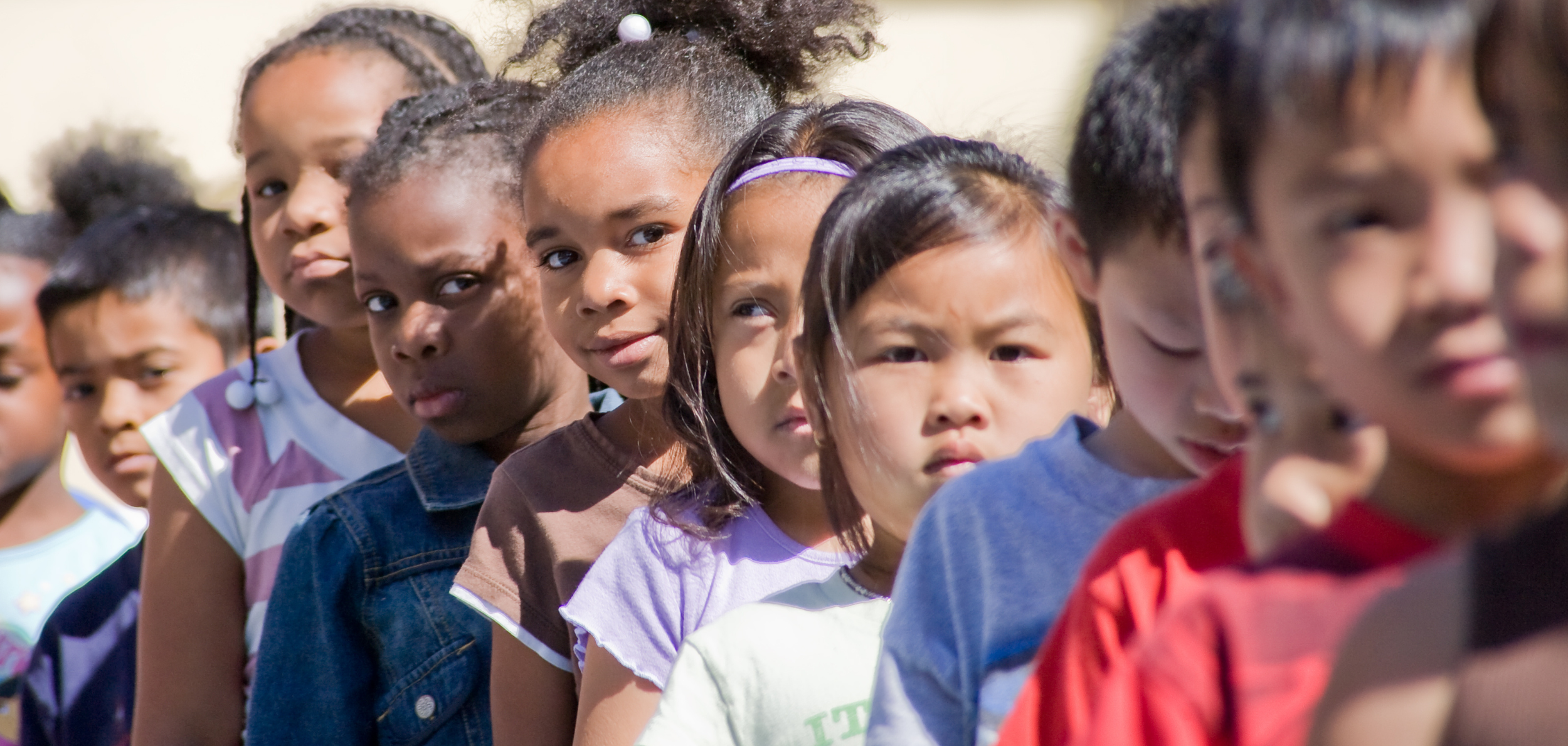 Close up of children, standing in a line on a playground