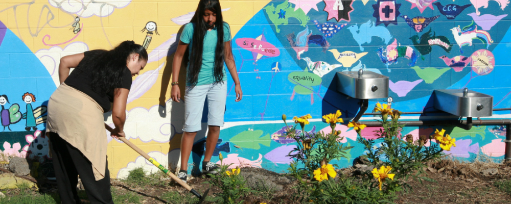 woman and younger girl tending to their community garden