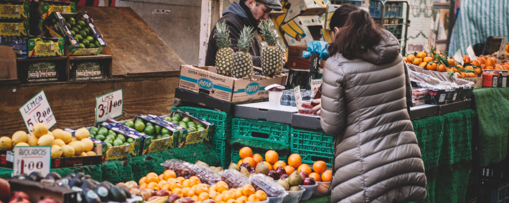 woman shopping for fruits and vegetables at a farmers market