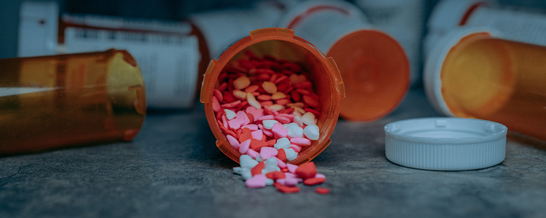 pink, white and read heart-shaped pills from a prescription bottle
