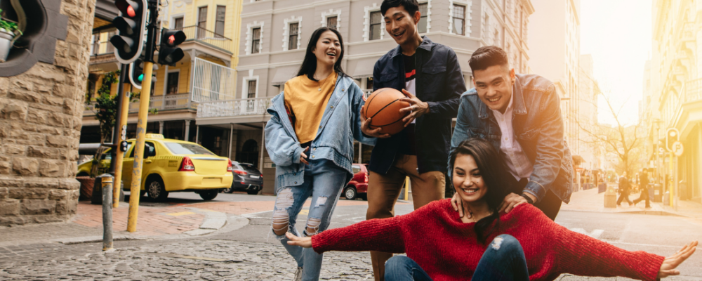 Four Asian young people, walking outside and smiling