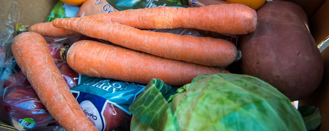 carrots, potatoes and cabbage loose in a cardboard box