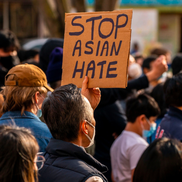 A group of people protesting. A person is holding a sign that reads "Stop Asian Hate."