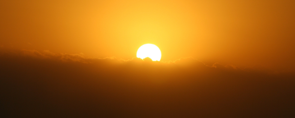 sun peaking over mountains