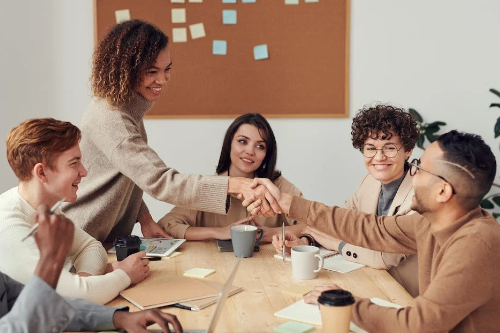 people shaking hands at desk