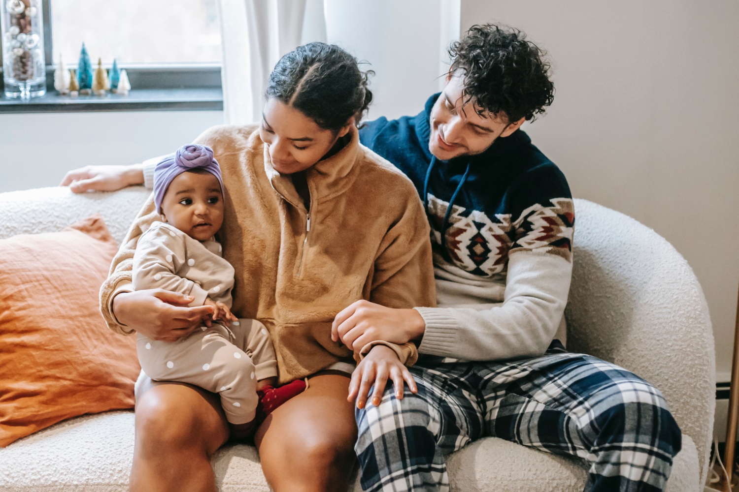 Family of three sitting on the couch together