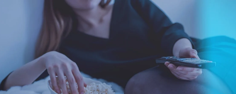 woman eating popcorn watching tv