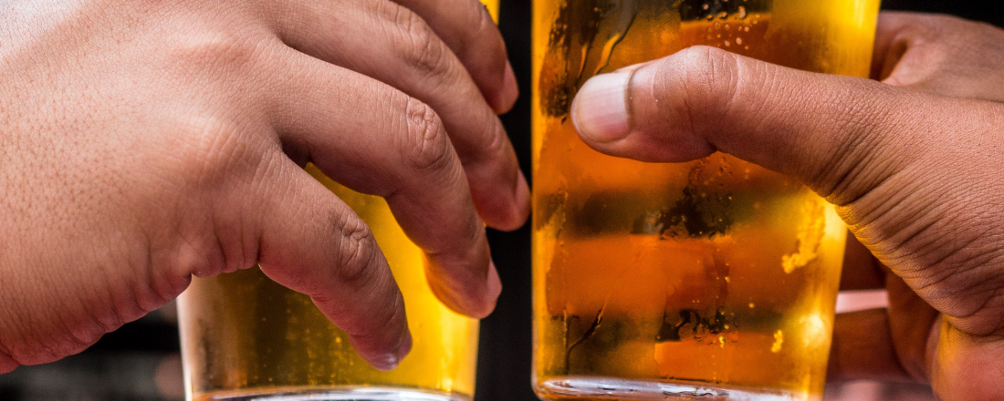 two people drinking alcohol and doing cheers with their glass