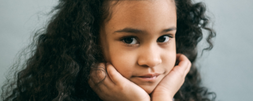 little girl with hands on her chin