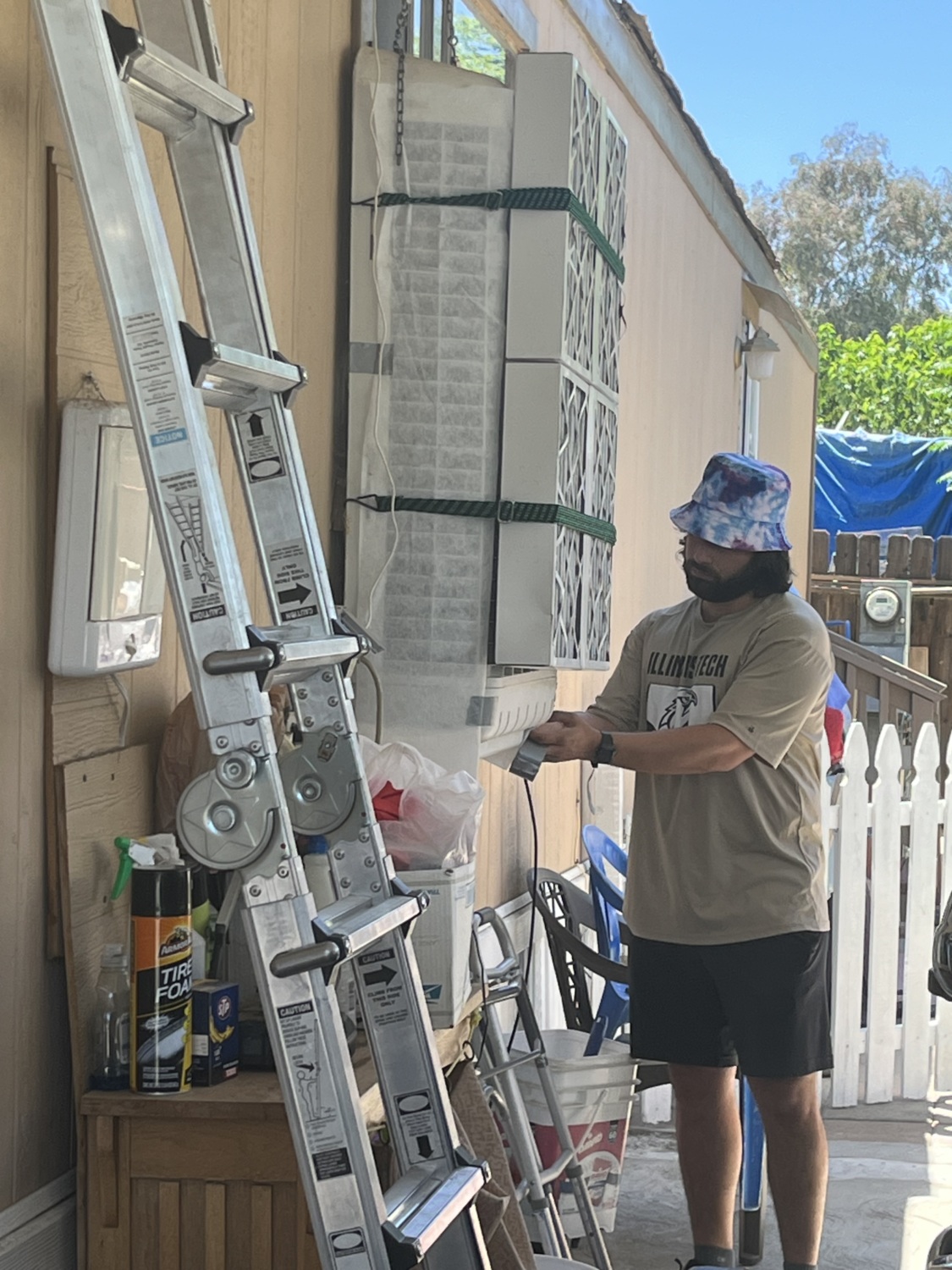 FRESSCA intern installs air filter on a swamp cooler outside a home in Coalinga, CA