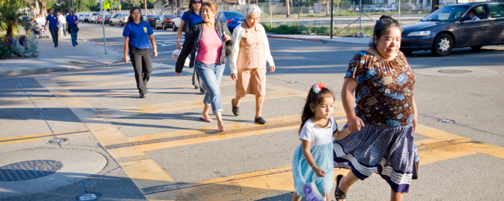Grandmother and grandchild crossing the street at a crosswalk