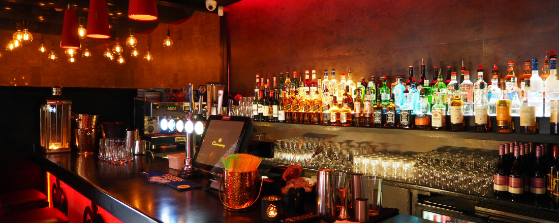 a bar with bottles of alcohol on a shelf