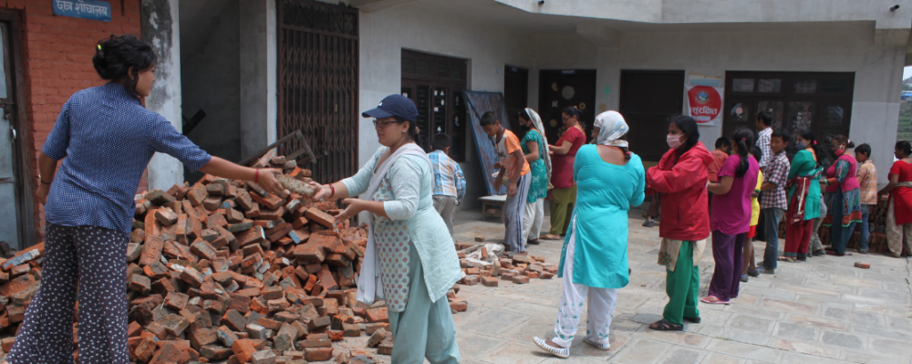 group of people in line passing each other bricks