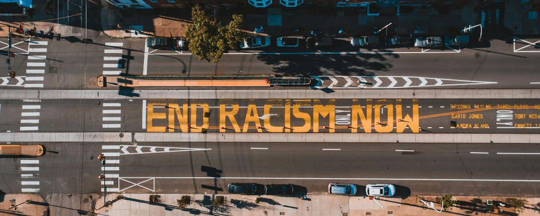 street with the words end racism now painted in yellow