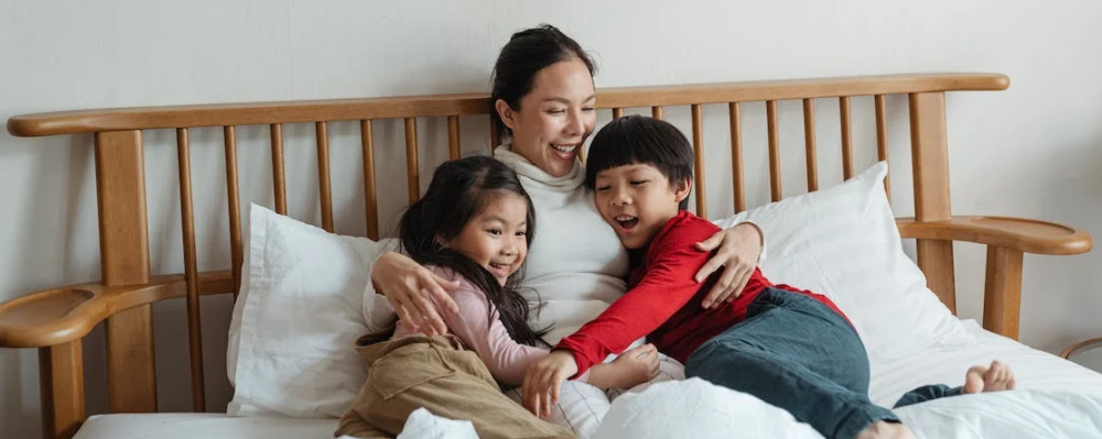 Asian mother and children sitting on couch