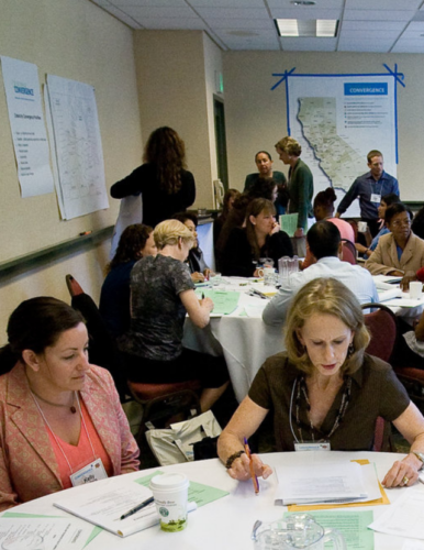group of people in a meeting with california map in the background