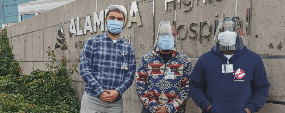 Bridge staff in front of hospital sign