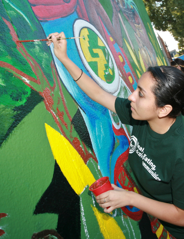 Young people painting a mural