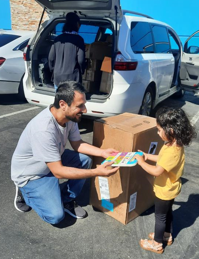 man giving a childrens book to child